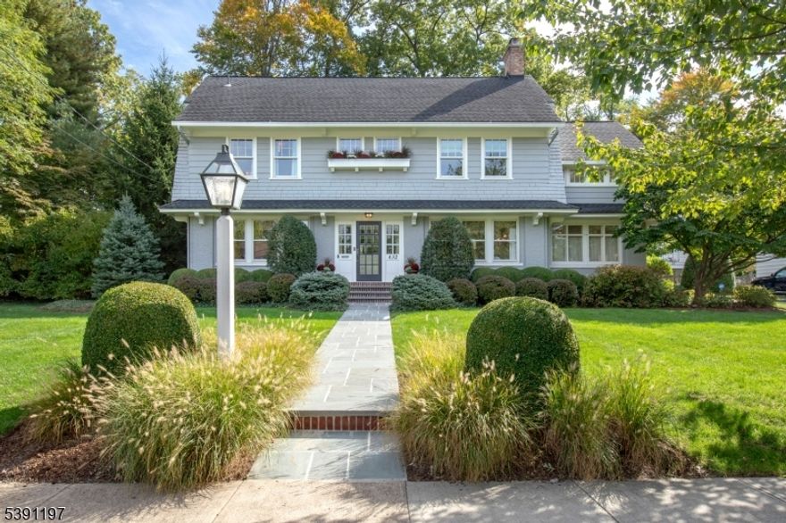 Location. Lifestyle. Luxury. Beautifully appointed interiors. Classic elegance. This center hall colonial blends classic architectural Details with modern amenities. Situated on one of only a few flat streets in Maplewood, it's just three-quarters of a mile from the train and village. The foyer, with leaded glass windows and newly refinished hardwood floors, leads to a spacious living room featuring leaded glass shelves and a wood-burning fireplace. Adjacent is a family room, perfect for relaxing. The formal dining room is ideal for large gathering dinners. A chef's eat-in kitchen BOAsts high-end appliances, granite countertops, and a banquette. Additional features include a pantry with a wine refrigerator. The finished basement with a powder room, perfect for a playroom or game room, includes a separate laundry room. The second floor has four bedrooms and a bonus room with a cathedral ceiling, a brick chimney wall and an antique, leaded glass window. The primary bedroom has a walk-in closet and renovated bath. A renovated hallway bath has a double vanity and full tub. The third floor features a private, ensuite bedroom. A large patio overlooks an expansive backyard. The detached three-bay garage includes a climbing wall and loft. A backyard gate provides access to a coveted private back lane where neighbors gather to socialize and play.