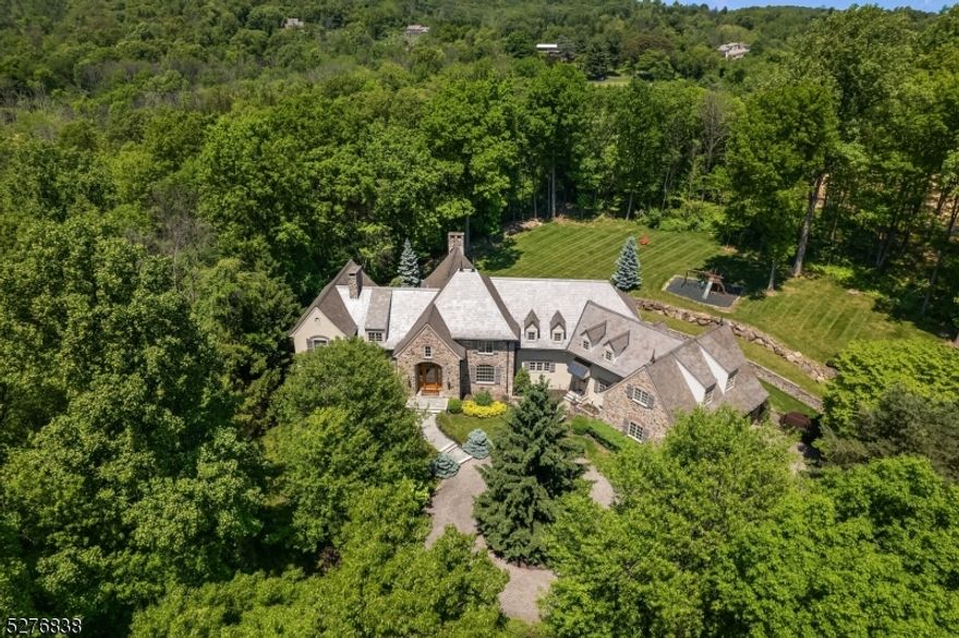 In the charming hamlet of Mountainville, this sophisticated country manor home offers refined living on 7+ beautifully landscaped acres. The exterior showcases a striking blend of stone, stucco, and cedar siding, accented by a slate roof and stone chimneys. A bluestone walkway leads to the entry, where you are welcomed into the spacious and well-appointed interior. Inside the stunning residence, recent modern updates are enhanced by extensive custom architectural mouldings and millwork throughout. The centerpiece of the residence is the gourmet kitchen and expansive two-story Great Room, featuring a floor-to-ceiling fieldstone fireplace and wet bar. The primary suite is a luxurious retreat, complete with a large bedroom, sitting room with fireplace and sumptuous bath. Additional highlights include 5 fireplaces, gallery art walls, a private in-law suite, and a 3-level elevator. The walkout lower level offers ample space for entertainment, featuring a family room with fireplace and wet bar, gym, media room and office. Outside, the home boasts covered patios, stone walls, terraced landscape, and a bluestone patio with an outdoor kitchen for dining and entertaining. A paver circular drive and motor court provide ample parking, while the 3-car garage with stone entries and carriage doors add to the property's charm. With its impeccable craftsmanship, versatile living spaces, and picturesque surroundings, this offering is a rare opportunity to experience luxurious country living.