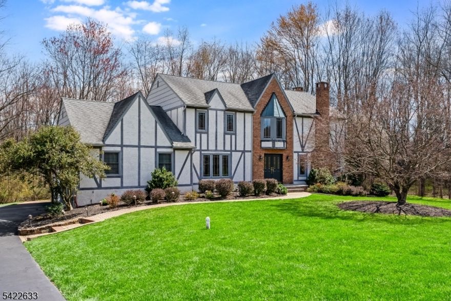 This Tudor-style center hall Colonial is set on the south side of town with easy access to downtown and Route 287 and is exceptionally well maintained. The home offers a spacious eat-in kitchen with French doors opening to a rear deck, newer Andersen windows, hardwood floors, and two gas fireplaces. Features include a first-floor office, four well-proportioned bedrooms, a full finished basement, central air conditioning, baseboard heat, public utilities, a whole-house generator, and fresh interior paint throughout. The foyer is welcoming, with generous closet space, and opens to a living room filled with natural light from windows on two sides, centered around a gas fireplace with brick surround and wood mantel. The kitchen features recessed lighting, granite-topped peninsula counters, stainless steel gas range, vented microwave, and refrigerator, and flows directly into a comfortable family room with a wood-burning fireplace.  A two-car garage connects directly to a functional mudroom with powder room, double closets, and laundry area with gas hookup. A Trex-style deck overlooks the rear yard, all within a well-established neighborhood known for its appeal and convenience.