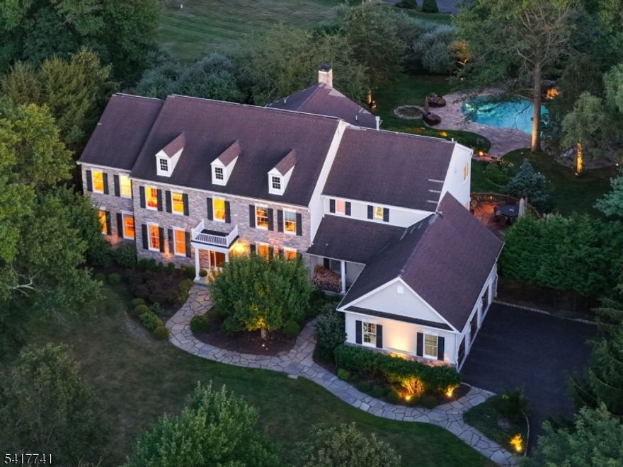 Enjoy luxury living in Canterbury Estates, one of the most coveted communities in Basking Ridge. Situated on a cul-de-sac, this extraordinary 6 bedroom, 6.2 bath home with nine foot ceilings faces northwest, providing abundant sunlight throughout the day. A stunning oak staircase makes an immediate statement in the two-story foyer. The expansive kitchen features Yorktowne cabinetry, quartzite countertops, premium appliances, breakfast room, and opens to the Ipe deck with tranquil views. A back staircase in the kitchen adds convenience. The family room is anchored by a floor-to-ceiling cultured stone fireplace, coffered ceiling, and double windows with views of the skyline, garden and pool. The conservatory also offers incredible views plus a double pass-through to the gallery and living room. Builder upgrades include a private work area and second floor laundry. All six bedrooms are en-suite. The primary suite offers volume ceilings, sitting room, generously sized walk-in closet, bath with double vanity, jetted tub, & walk-in shower. The walkout lower level, which opens to the patio, features a bedroom with en-suite bath, flexible game, recreation & dining areas plus ample storage.Your outdoor retreat awaits with meticulously landscaped level yard, heated gunite pool, waterfall, stone decking, stone patio, outdoor kitchen with built-in Lynx grill, and firepit. Schools are nationally ranked. Easy access to Rte 78 and 287. Pre-wired for Tesla charger. Exceptional in every way!