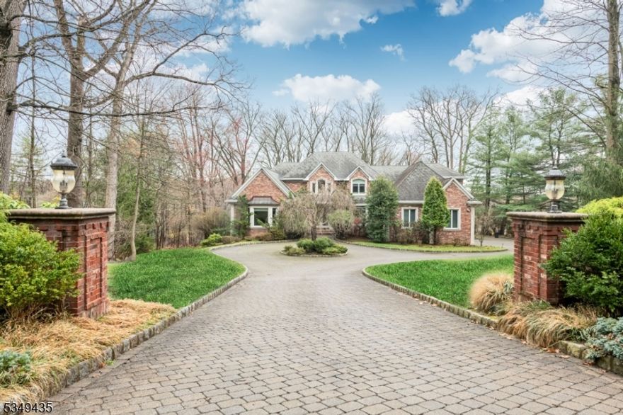 Welcome to this gorgeous, custom-built brick colonial nestled on two serene acres in the coveted High Ridge neighborhood, known for its large lots and private retreats. Built in 2001 with the exceptional craftsmanship of Leonard Developers, this home offers a modern floor plan with sunlit rooms, an elegant two-story entry foyer, and an oversized gourmet kitchen with a dining area that overlooks natural views. The soaring great room adds a sense of grandeur, with a floor-to-ceiling stone fireplace, while the first-floor primary suite provides convenient one-floor living. Enjoy easy access to a laundry room, plus a versatile fifth bedroom or office. The upper level offers three spacious bedrooms including a junior suite, abundant storage space, and an unfinished section perfect for expansion. The sizeable, walk-out lower level is a blank canvas for more than 3,000 square feet of additional living space, already complete with a fireplace and full bath. Integrating the interior with the landscape, a wide veranda stretches across most of the house and is ideal for entertaining or relaxing while overlooking the private, tree-lined property. Beneath is a patio accented by three beautiful, curved archways. A custom paver driveway and three-car garage complete the package. Come view this embodiment of comfortable sophistication!