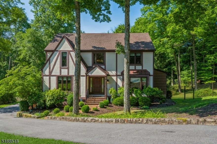 Casual elegance in a perfect location!Stunning and spotless Colonial home with four bedrooms, two and a half bathrooms, and loads of curb appeal is nestled on nearly two acres of manicured property in this sought-after community. This home is near schools, stores, whole variety of restaurants, cultural attractions, and less than ten minutes to the NJ transit direct train to New York City. Highlights include beautiful hardwood floors, crown molding, a sunroom, a deck, and a partially finished basement. Beyond the welcoming front entryway, the large two-story foyer has parquet floors and French doors opening to the living room with a lovely casement window. The formal dining room features a chair rail with room for a crowd or a cozy dinner for two. The bright, open kitchen is equipped with white counters, stainless steel appliances, and warm wood cabinetry. Glass doors in the adjacent breakfast area open to a gorgeous greenhouse-style sunroom with sliders to the large deck overlooking the expansive, private fully fenced back yard, complemented by a stream. The open layout continues to a comfortable family room with a cozy wood-burning fireplace. Off the kitchen is a laundry room and a half bathroom. The second floor primary bedroom includes an en suite bathroom with a jetted soaking tub. There are three additional bedrooms and a full hallway bathroom on this level. The partially finished basement offers a large recreation room, garage entrance and ample storage.