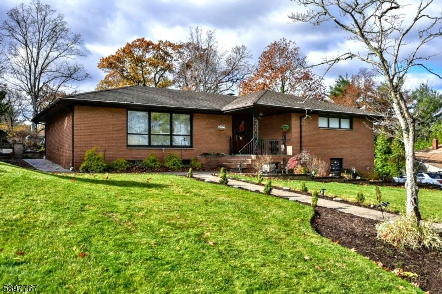 A wonderful opportunity awaits with this beautifully crafted custom brick ranch. Step inside to a warm foyer with flagstone flooring, spacious formal living and dining room, with gleaming hardwood floors throughout. The maple gourmet eat-in-kitchen features newer stainless steel appliances, plenty of room for cooking and entertaining. Relax in a very impressive family room with custom cabinetry, granite countertops, gas fireplace, oak ceiling with skylight and abundant windows that frame backyard views. Two sets of sliding glass doors lead to patio and deck. The main level offers two generous size bedrooms, two full baths, formal living room, dining room, family room, kitchen and a convenient laundry area with built in iron board. The primary suite includes a full bath and large walk in closet. There's so much more to this home than meets the eye. The fully finished lower level offers incredible flexibility, featuring a private entrance with endless possibilities for living space. The layout opportunity includes a large bedroom space, comfortable family room, office, full bath, perfect for guests, or work-from-home needs. Outside, enjoy the private two tiered backyard with Cambridge paver patio, bluestone tile, covered gazebo, gas grill, granite counter top, and refrigerator. Home has oversized 2 car garage. 2 yr old underground sprinkler system, 1 yr old security system. Close to shopping, transportation, NYC. Don't miss out. A must see!