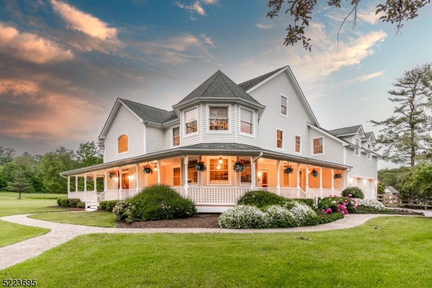 This stunning farmhouse retreat situated on 70+ acre farm near the charming historic river towns. Welcomed by a cozy wrap-around porch leading into an elegant two-story foyer. This custom-built home boasting large rooms filled with natural light and beautiful radiant heated, random-width hardwood floors, creating a warmly inviting ambiance. The open-concept design enables effortless entertaining and relaxation with an abundance of windows allowing panoramic views of the surrounding vista. The main floor features an oversized gourmet kitchen offering a large pantry with a coffee station, granite counters and island for seating, an impressive two-sided floor to ceiling, wood-burning stone fireplace with a pizza oven, a great room opening to the patio, a formal dining room with a stone fireplace, a breakfast area, formal living room and a spacious home office with a half bath and its own entrance. A powder room and mudroom leading out onto the patio oasis completes the main level. The second floor houses a luxurious primary suite with a gas fireplace, a lavish bathroom, walk-in closets and a sunroom overlooking the fields, as well as 3 guest bedrooms that share two hall bathrooms, and a generous en-suite bedroom, and a nearby laundry room. A bonus rm & attic are on the top level. An outdoor kitchen on an expansive patio with a heated pool beside the charming pool house is ideal for entertaining. An 80x50 workshop, 4 car garage offers many uses. Horse Enthusiasts are welcome!