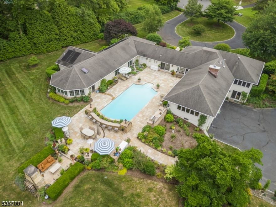 Set on 2.7-acre lot at the end of a cul-de-sac, this exceptional estate offers a combination of luxury, privacy, and convenience. Surrounded by mature trees and landscaped grounds, the home is a private retreat just minutes from Natirar and the heart of town. Inside to discover a flowing floor plan with expansive windows that frame the stunning backyard oasis featuring a heated pool, custom stone fireplace, built-in BBQ, and expansive patio all offering a true resort-style experience. Inside, the formal dining room boasts intricate moldings and custom built-ins while the kitchen impresses with high-end appliances, a center island w seating, and a sun-drenched breakfast room. Adjacent is a cozy FR with a gas f/p, built-in shelving, and dry bar. Sharing the fireplace, the formal LR features tray ceilings, walls of windows, and a window seats with built-in storage. A private bedroom with a full bath is tucked away on this side of the home is perfect for visitors. On the opposite wing, the luxurious primary suite serves as a true sanctuary, offering a walk-in closet, custom built-in desk, tray ceiling, and a spa-inspired bath with jetted tub, steam shower, and garden views. A sun-filled hot tub room with walls of windows completes the primary suite with pool access. Two add'l bedrooms share a well-appointed bathroom.  This level also features a handsome office w ensuite bath, laundry room and powder room.  Finished walk out LL with full bathroom.  Public utilities...A Must see!