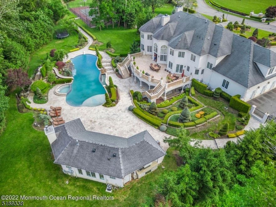 Perfectly nestled on 4 acres of exquisite estate land that is intricately landscaped & designed. With 8317 sq ft of breath-taking construction & an add. 4000 sq ft bsmt there is 12,317 sq ft of living. This incredible home offers a stucco exterior with a paved circular driveway that leads to a breath-taking two-story foyer & 10' ceilings throughout. This estate provides exquisite amenities and 7 large bedrooms with custom walk-in closets, each with access to a full private bathroom. The first floor provides an office/ library space-ideal for home-based work! The oversized great room features custom Palladium windows for plenty of natural light. The dining and living spaces lead to the butlers' pantry and gourmet kitchen designed with custom cabinetry and granite countertops to match the high-end stainless steel sub-zero commercial-grade appliances. The upstairs level features a majestic master suite with two custom closets, a spa-like en-suite bath, and an ornate granite-lined gas fireplace in the sitting area. The interior balcony leads to the opposing wing of the home which features four generously sized bedrooms, each sharing the distinguishable custom moldings and tasteful details found throughout the home. The interior of this home is complete with an immaculately finished walk-out basement that will leave any avid entertainer speechless. And when you're ready to settle down and enjoy the fully equipped theater room, wet bar or spa amenities - now that is luxury living!