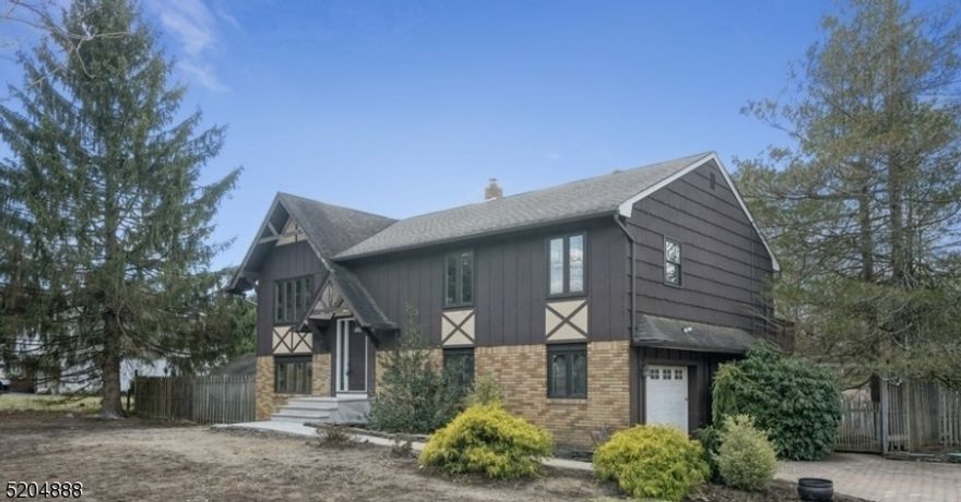 Picturesque retreat is move-in ready and conveniently located! Impeccable Bi-Level home with many updates & a rustic vibe. Close to Lake Mohawk.  You'll enjoy a wealth of outdoor activities at your fingertips, along with quick access to shopping, dining, schools & RT 15 & 80. Nestled on a park-like corner lot on a quiet street, this home features refinished wood floors, new windows, a renovated primary bathroom, new boiler & new eco-friendly septic. A sprawling, wrap-around deck & patio make an ideal setting for warm weather entertaining &relaxing on half an acre of manicured, fenced-in property. On the main level, beautiful hardwood floors gleam across the large & bright living room & dining area. The eat-in country kitchen includes exposed brick accents, warm wood cabinetry & a wood-beamed ceiling. The primary bed w/en-suite bath & sliding glass doors to its own private deck, plus 2 addt'l bedrooms & bathroom. On the ground level is a spacious family room with a free-standing wood-burning fireplace set in a corner lined with natural stone. French doors open to a 3-season sunroom enveloped in light with a set of sliding glass doors leading to the multi-level deck in the private backyard. An office/guest room, laundry room & access to the attached one-car garage complete this level.