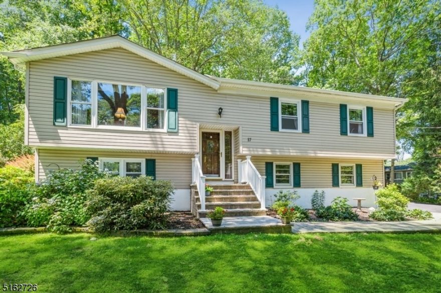 Spacious, move-in ready home in a peaceful location! Pride of ownership is evident throughout this beautiful Bi-Level home. Set on a manicured half-acre lot on a tree-lined street, this property offers a generous amount of outdoor space including a deck and a ground-level stone paver patio overlooking the deep and private backyard. A welcoming front entry invites you inside to an open, sun-filled layout on the main level featuring gleaming hardwood floors, crown molding, and abundant natural light. With a big picture window on one side and sliding glass doors on the other, the bright LR and dining area flow effortlessly to the open, eat-in kitchen. Preparing meals is a delight with quartz counters, tile backsplash, SS appliances, warm oak cabinetry, space for a dinette set, and views of the beautiful back yard. Down the hall you'll find the primary bedroom w/a sizable closet and full en suite bth, one bedroom, an office, and a full hall bathroom. The lower level offers a comfortable FR w/a cozy wood-burning stove, a third large bedroom, laundry/half bathroom, and access to the attached garage.  Enjoy morning coffee on the deck with treetop views and warm weather evenings entertaining or just relaxing on the patio in peaceful privacy. A large storage shed completes the package. To top it all off, this home is ideally located near schools, stores, restaurants, and such local area attractions as Budd Lake, Lake Hopatcong, Wild West City, and Waterloo Village.