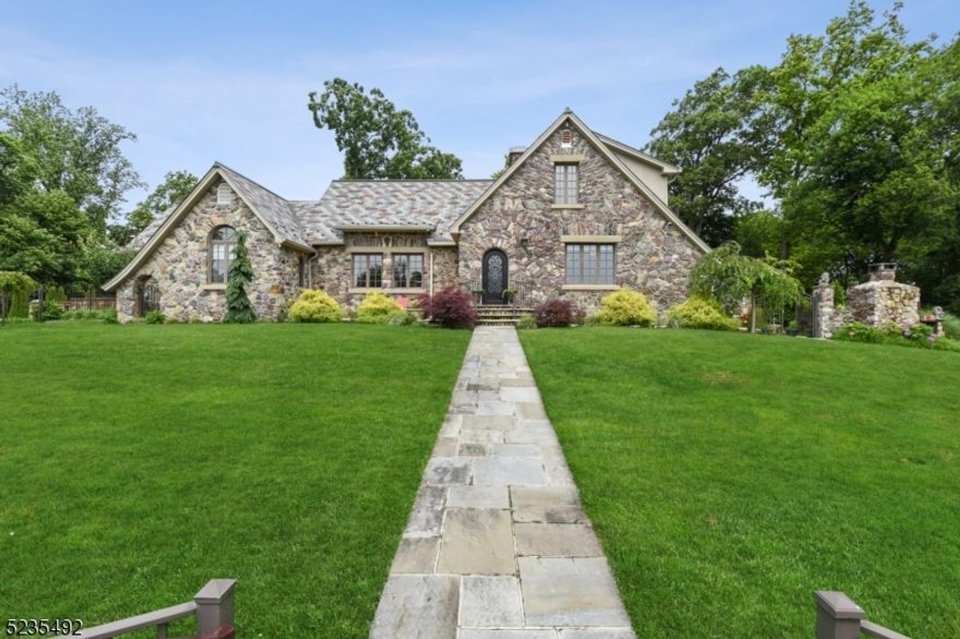 Spectacular CUSTOM stone manor home rests on an acre of beautifully landscaped property on top of the Watchung Reservation boasting spectacular views. Totally renovated in 2017 by the owner/builder, this one-of-a-kind home is loaded with designer features, beamed ceilings, millwork and gorgeous hardwood floors throughout. Be prepared to be blown away the moment to step into the great room that features a custom wood cathedral ceiling and a two-story stone fireplace. The large EIK features stainless steel GE Monogram appliances, granite counters and the private breakfast room with a beautiful domed wood ceiling is the perfect place to start your day. The spacious 1st floor primary bedroom includes a spa-like bath with a stall shower and jetted tub. The 2nd floor includes two additional bedrooms, a full bath and a balcony overlooking the great room. The walkout finished lower level is massive and includes a rec. room with new LVT flooring, home office, exercise room, summer kitchen with dining area, half bath and a laundry room. Entertain loved ones outside by the heated pool with waterfall and enjoy a meal on the additional patio by the natural stone BBQ grill. The gut renovation included new kitchen and baths, floors, electric & plumbing, 4-zone HVAC & drywall.  All custom interior doors were restored. Also features Pella windows, long driveway can accommodate approx. 12+ cars, plenty of yard space, sprinklers, garden & much more! This is truly a must see!