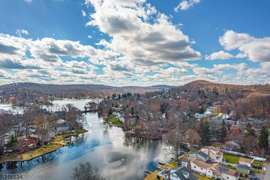 LAKEFRONT on Indian Lake! Bright, sunny living room with large picture window and balcony. Stunning Hardwood Floors. Formal Dining opens to three tier deck w/beautiful lake views year round. Open kitchen with Sink overlooking Sunset Bay. Spacious living, sweet spot! Lovingly cared for over 20 years. 4 Bedrooms and 2 Full Baths. Lovely ground floor family room with wood burning stove. Sliders to fenced in backyard. Add a dock and a boat and enjoy all the best of Lake Life. Direct access to "main lake" under Franklin Rd bridge. Wonderful, warm home for everyday living & entertaining. Laundry room, 1 car garage & lots of storage throughout. Beautiful, large, level lot. Solar panels on roof for efficiency. Super convenient location for commuting to NYC on train, bus + major highways. Situated in Indian Lake- with membership enjoy all the amenities- swimming, boating, fishing, iceskating, etc! Tons of clubhouse activities & fun for people of all ages. Walk to bustling Downtown Denville- voted best town in Morris County. TOP schools!