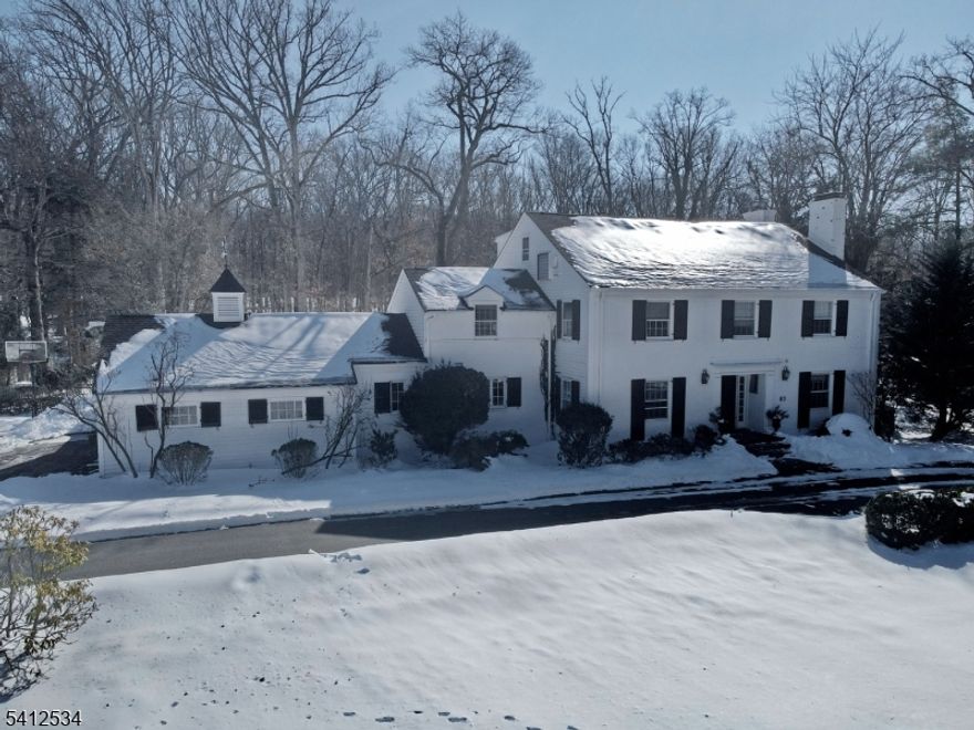 Nestled in one of Essex County's most desirable areas, this secluded custom-built colonial on nearly 2 acres encompasses 5 beds, 7 baths, a guest house/home office addition (2007), an in-ground pool, a huge backyard, and every amenity one could want. The distinctive interior features deep crown moldings and trim, 8 inch wood plank flooring, 4 fireplaces, and custom details throughout. A semi-circular driveway brings you to the bright and spacious foyer opening to a classic library with wood planked floors and built-in shelving. The flow continues to the formal dining room with a picture window and the living room with a fireplace and a wall of glass French doors to the bluestone patio and custom fieldstone outdoor kitchen and bar. A first floor gym has 3 sets of sliding glass doors to the outside. Top-of-the-line appliances, sparkling white cabinetry, and an oversized island make the kitchen as functional as it is stunning. Off the kitchen is a large mudroom with 4 closets, a laundry room, and a half bath. Completing the main level is a large great room and a guest house/home office with its own separate entrance and private porch. Upstairs the luxurious primary bedroom suite with a sitting room and a private en suite featuring a soaking tub and an oversized glass shower.There are 2 large bedrooms on this level, one featuring its own full en suite bath plus a full main bathroom in the hall, and 2 more bedrooms and a full bath on the 3rd floor.