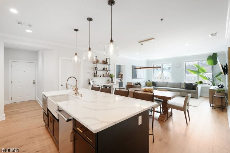 Hoboken living at its finest. This sun-filled penthouse has been extensively renovated with no expense spared, offering true turnkey living for both everyday comfort and entertaining. A full 2022 renovation delivered a redesigned kitchen with custom soft-close cabinetry, floor-to-ceiling storage, pro-style Thermador appliances, a quartz island with cabinetry on both sides, and a farmhouse sink. A built-in bar with dual-zone wine refrigerator and custom iron shelving adds a refined touch for hosting. Additional upgrades include wide-plank oak flooring, updated laundry machines, oversized HVAC installed in 2023 with WiFi-enabled thermostat, Pella windows, and Bali blackout blinds. Both bathrooms were fully renovated with slate and Carrara marble finishes and recessed medicine cabinets. The home offers exceptional storage throughout, including multiple pantries, a walk-in primary closet with custom organizers, and a secondary bedroom with a John Louis Home closet system. An open floor plan, high ceilings, and abundant natural light create an airy feel throughout. Outdoor space includes a private rooftop deck with NYC views and a shared backyard. Boutique elevator building with heated garage parking and additional storage, ideally located near the Light Rail, Monroe Center, and the 126 Bus to NYC.