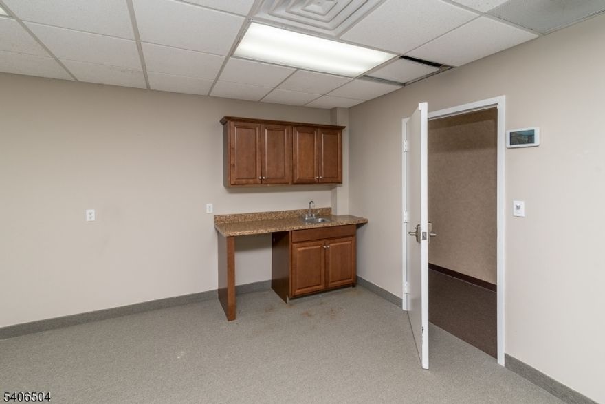 Welcome to this efficient and well-appointed 511 SF first-floor office suite offering a functional layout ideal for small businesses or professional use. The space features a large common area with a convenient kitchenette, perfect for daily operations or client meetings, along with a private enclosed office for focused work. The office is carpeted throughout and is located close to shared restrooms. The building offers ample on-site parking, providing easy access for both staff and visitors. A great option for startups, consultants, or satellite offices seeking comfort and convenience, come see this space today!