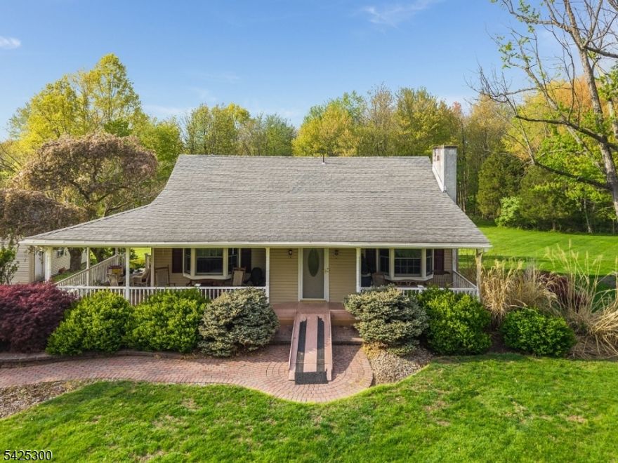 Welcome to this lovely home situated on 2.67 picturesque acres on a corner lot, backing to park-like land for added privacy and tranquility. Step onto the inviting covered front porch and into the cozy living room featuring a fireplace, ideal for relaxing evenings at home. Inside, you will find an updated kitchen with beautiful wood floors and a deck just off the kitchen-perfect for enjoying your morning coffee or unwinding with a glass of wine while watching the sunset. The main level offers two comfortable bedrooms, and bathroom. The upstairs bedroom also has access to its own private bath, creating a perfect retreat. The basement provides a dedicated laundry area along with ample space for storage or to suit your personal needs. Completing the property is a detached two-car garage-an ideal space for the hobbyist, additional storage, or workshop needs.Professional photos will be available this weekend