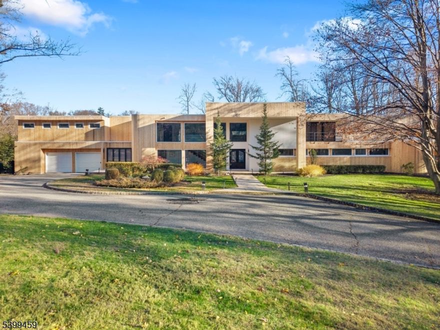 Welcome to 41 Park Way, a one-of-a-kind custom contemporary nestled in the prestigious gated community of Llewellyn Park, West Orange. Set on 2 private, park-like acres, this architecturally stunning home offers privacy, elegance, and convenience just 12 miles from Midtown NYC. Inside, you'll find a dramatic open floor plan with soaring ceilings and walls of glass that flood the home with natural light and provide serene views of the surrounding landscape. The gourmet chef's kitchen is a showstopper, featuring top-of-the-line appliances and custom finishes perfect for both daily living and entertaining on any scale. The expansive primary suite is a true retreat, boasting oversized walk-in closets and a beautifully renovated bath. Each room throughout the home is generously sized, with thoughtful custom details that elevate every corner. Enjoy the outdoors with a spacious backyard complete with a deck and patio ideal for gatherings or quiet reflection. Additional amenities include an exercise room, contemporary architectural lines, and unparalleled seclusion all within reach of major NYC transit options. A rare opportunity to own one of the most unique homes in The Park. Experience luxury, comfort, and timeless design at 41 Park Way.