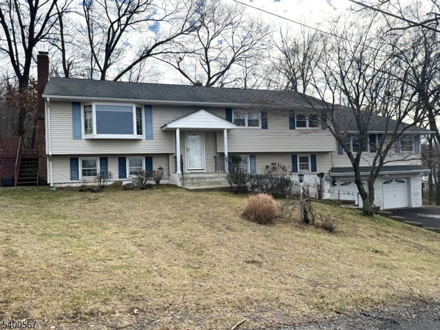 Welcome to this spacious Bi-Level home set on a peaceful cul-de-sac, offering privacy on a large .5-acre lot. With 5 bedrooms and 3 full bathrooms, this home provides flexible living space with potential for an in-law suite. The full finished lower level features a wet bar, along with slider access to a patio, as well as access to the 2-car garage. Enjoy cozy evenings by the gas fireplace in the living room, highlighted by a Bay Window that fills the space with natural light. Hardwood floors run through the bedrooms, while the kitchen boasts a skylight and sliders leading to a wraparound deck perfect for indoor-outdoor living. Additional highlights include a 3-season room, central A/C, a 5-zone furnace for efficient comfort, and two separate driveways for ample parking and much more! A rare opportunity combining space, versatility, and a serene setting.