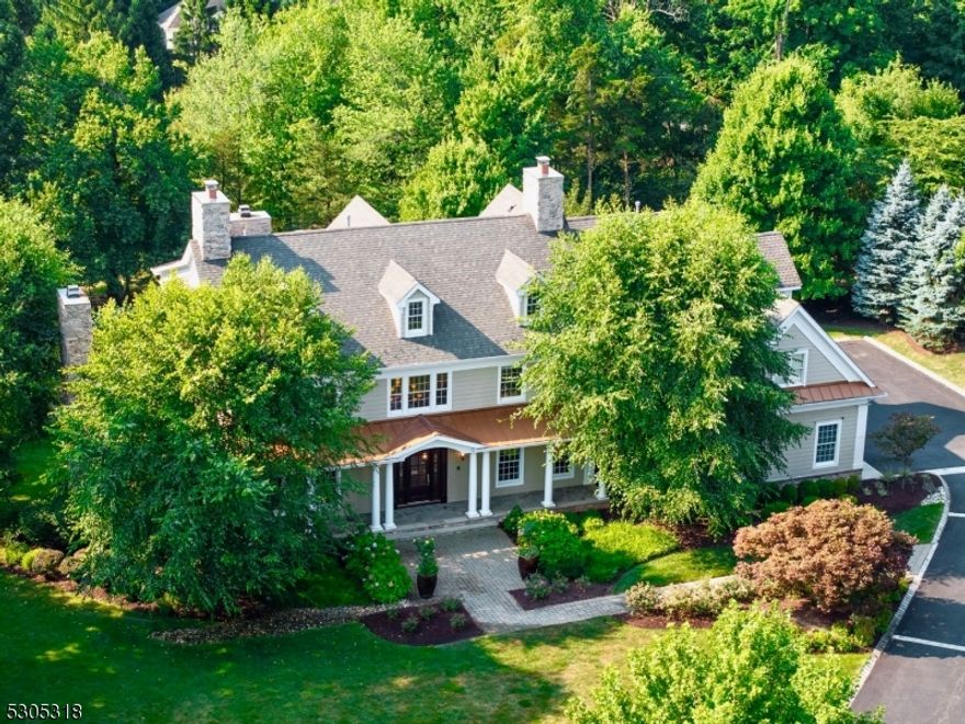 Situated on a tree-lined cul de sac with sweeping lawns and specimen plantings, this exceptional, north-facing home features beautiful millwork, coffered ceilings, and hardwood flooring. Past the bluestone front porch and custom mahogany door, the two-story foyer signals an air of sophistication. The open yet defined floor plan is enhanced by 9 ft ceilings and sun-drenched rooms. Arched doorways lead to the chef's kitchen with furniture quality cabinetry and Wolf/Sub-Zero appliances. Enjoy meal prep on the center island with ample seating and storage. Start your day in the adjoining breakfast room. Enjoy gatherings large or small in the exquisitely trimmed family room with bar and stone surround fireplace. A light-filled office with fireplace flows seamlessly from the living room; the formal dining room with Butler's pantry, first floor bedroom, full bath, and laundry room complete this level. Upstairs, the primary suite is a true sanctuary. Volume ceilings, double-sided gas fireplace, sitting room, two expansive walk-in closets, and spa quality bath provide the perfect respite. There are four additional bedrooms plus 3 full baths on this level. Entertain in the recently finished walkout lower level, complete with rec room, exquisite kitchenette, endless quartz center island, 7th bedroom, full bath, and sliders to the patio with firepit. Enjoy modern and smart conveniences: whole-house generator, Nest thermostats, 3-car garage w/shelving. Schools are nationally ranked.