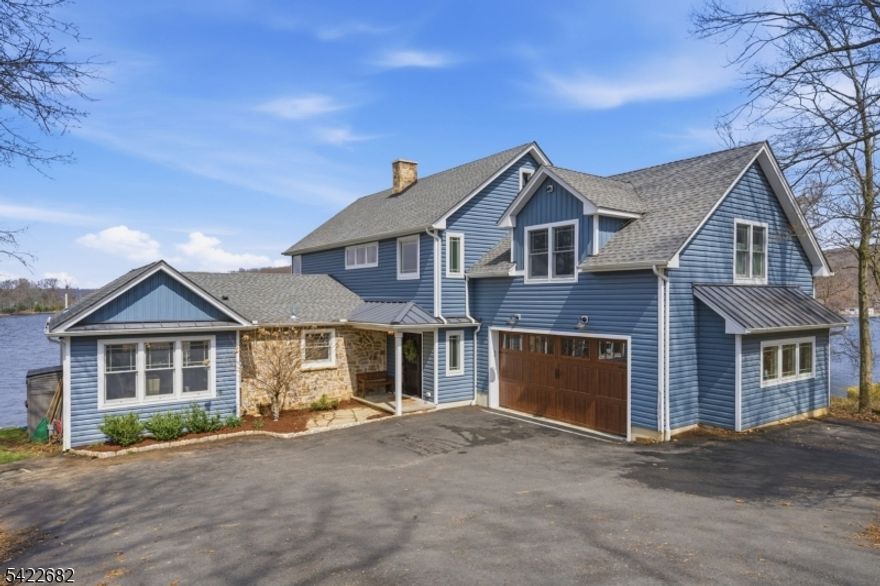 Experience elevated LAKEFRONT LIVING with MOTHER-DAUGHTER Setup on Lake Hopatcong, New Jerseys Largest Lake situated in Mount Arlington within 1 HOUR TO NYC! This residence was completely redone in 2023 and features 5 Bedrooms, 3 Full & 2 Half Baths plus an Oversized 2 Car Garage. Offering a STRAIGHT OUT OF A MAGAZINE Open-Concept Floor Plan with sweeping panoramic Lake Views & Modern sophistication designed for Entertaining and Flexibility. Enjoy an awe-inspiring Kitchen highlighted by a Center Island with Breakfast Bar, Quartz Countertops, High-End Appliances, custom Cabinetry, Backsplash & Pot Filler. The MASSIVE Primary Suite with incredible Lake Views provides Cathedral Ceilings, a BONUS Adjoining Suite that can be used as another Bedroom, Office, Gym or Recreation Room, an Ensuite Bathroom with 2 Half Baths & 2 Walk-In Closets. The separate entrance Mother Daughter setup features a second Kitchen, separate Living area, Bedroom, Full Bathroom, Laundry Room & private Deck. Embrace true lake life with amenities including Boating, Jet Skiing, Swimming, Fishing, Waterfront Dining and year-round recreation right outside your door. Live like you are on vacation every day! Residents also benefit from highly regarded schools including Mount Arlington Public Schools and Roxbury Township Public Schools. Offering Public Utilities (Public Sewer, Public Water & Natural Gas!)
