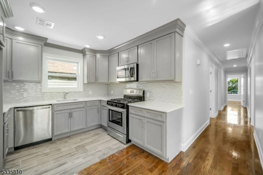 Welcome to this newly constructed third-floor apartment, where modern luxury meets everyday convenience! This spacious 3-bedroom, 2-bathroom home is designed with high-end finishes and contemporary features for an exceptional living experience. Step inside to an open-concept layout featuring a bright and airy living room, dedicated dining area, and a sleek kitchen equipped with stainless steel appliances, elegant granite countertops, and ample cabinetry perfect for both entertaining and everyday living. The primary suite is a true retreat, boasting a luxurious en-suite bathroom with a dual vanity and a tub/shower combo for added comfort and convenience plus walk in closet. The hallway bathroom is thoughtfully positioned near the living area and secondary bedrooms, making it easily accessible for guests and residents alike. Hardwood flooring runs throughout the living spaces, while the bathrooms and kitchen feature timeless tile flooring. Additional conveniences include in-unit laundry with a full-size washer and dryer, forced heat, and central air conditioning to keep you comfortable year-round. Nestled on a quiet residential street, this home offers a peaceful retreat while keeping you connected. Commuting is effortless with quick access to I-280, the PATH, and NJ Transit train stations, making travel to Newark, Hoboken, or NYC a breeze. Plus, enjoy the convenience of nearby shops, restaurants, and local amenities just minutes away!