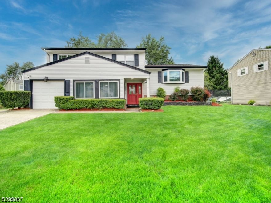 Presenting, this well maintained, 4 bedroom, 2.5 bath home that is every commuters dream, and it's conveniently located just one block away from the elementary school. The home's main level features a central kitchen design where everything is easily accessible, stainless steel appliances and sliding doors that lead to entertaining sized gazebo-style deck which overlooks a beautiful treelined back yard. Spacious living & dining rooms with lovely wood floors & recessed lighting, beautifully renovated full bathrooms, both with heated floors and three spacious  bedrooms on main level also with wood flooring. The large fourth bedroom is located on the ground level. The first floor also has a large foyer and den which accesses the garage, gas oven & sliders that leads to outdoor patio/yard. A half bath and laundry room with newer stackable washer & dryer, complete the ground level. PUBLIC UTILITIES HERE!