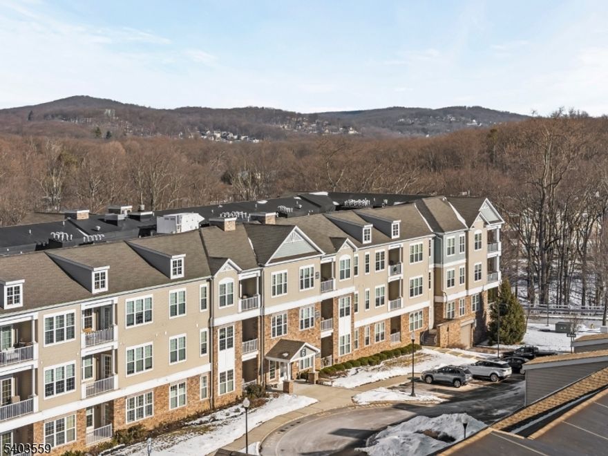 Refined third-floor Kittatinny model offering a sun-filled, open-concept layout with freshly painted interiors, soaring ceilings, and elegant crown molding throughout. The living and dining areas feature hardwood flooring and open to a covered balcony, creating a seamless indoor-outdoor retreat. A private den or study adds flexibility and sophistication to the living space. The kitchen is beautifully finished with granite countertops, stainless steel appliances, a breakfast bar, and generous cabinetry. The primary suite serves as a serene escape, complete with a sitting or dressing area, walk-in closet, ceiling fan, and plush carpeting. The spa-inspired en-suite bath features ceramic tile flooring, a granite vanity, and an oversized shower. Additional conveniences include a tiled laundry room, powder room, and one assigned garage space with opener and storage. Residents enjoy an exceptional Greenbriar 55+ resort lifestyle, featuring elevators, elegant lobby spaces, a clubhouse, fitness center, indoor and outdoor pools, tennis and bocce courts, scenic walking trails, and a full calendar of amenities, all just minutes from shopping and dining  One or more images have been virtually staged to show potential use of space.