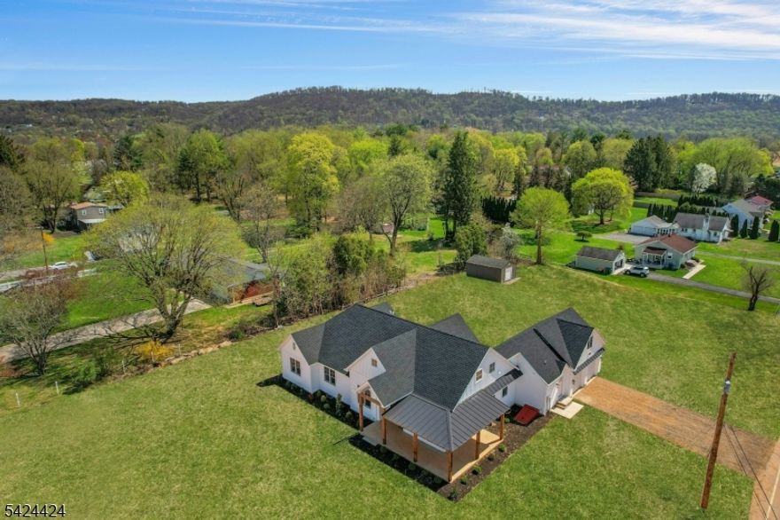 This custom-built new construction ranch sits on 1.4 acres with open views across the surrounding hills and Warren County countryside, offering a rare blend of space, flexibility, and modern design. A covered wraparound front porch with exposed natural wood beams overlooks the scenery and leads to a double-entry front door.Inside, the open floor plan features 10-foot ceilings, oak hardwood floors, gas fire place and high-end finishes throughout. The layout includes four bedrooms and 2.5 baths, all on the main level. The bathrooms are spa-inspired, with custom glass showers, soaking tubs, and clean, modern finishes. The primary suite includes two walk-in closets and French doors.A true chef's kitchen outfitted with Thermador appliances, wet bar and a large walk-in pantry, with a powder room conveniently located nearby. Additional features include custom closets, Andersen windows and doors, an on-demand hot water system, high-efficiency HVAC, a dedicated laundry room, and an attached two-car garage.The property offers ample room for a pool, carriage house, and personalized landscaping. Public water and natural gas, a brand-new septic system, paved driveway, and side entrance round out the exterior amenities.  A large unfinished loft offers storage or future expansion, and the huge full walk-out basement ready to be finished if desired.Located just three minutes from Route 78, the home offers an easy commute approximately 45 minutes to New York City and one hour to Philadelphia