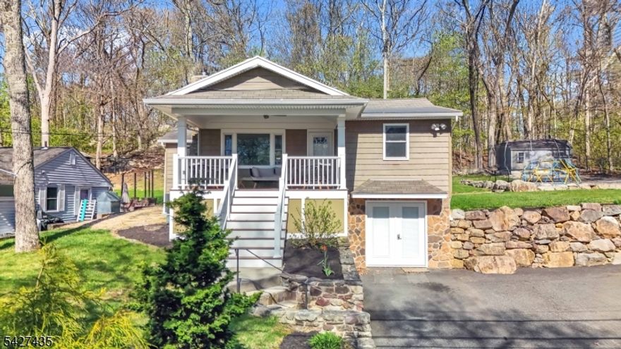 Oh, You Will Love this Front Porch! Charming, Fully Updated 2-bedroom Lake Style Ranch located in the desirable Lake Shawnee, where everyday living feels like a Vacation. Enjoy access to lake amenities including swimming, fishing, kayaking, paddle boarding, and sandy beaches, all within a welcoming community setting. This Home greets you with a Stunning Oversized Covered Front Porch, complete with recessed lighting and ceiling fan, offering the perfect outdoor space for relaxing or entertaining. Inside, a cozy Wood-Burning Stove insert warms the Living area, while the Beautiful Kitchen features Vaulted Ceilings, Skylights, a built-in storage bench, and opens seamlessly to the living room. Completely updated and Move-In Ready, every detail reflects pride of ownership. The Walkout Basement has been thoughtfully finished with a Family room, Custom Closets, Barn Door leading to the Laundry area, and a powder room. Sliders off the Kitchen lead to a large, private backyard backing to woods, creating a peaceful outdoor retreat. Convenient for commuters and close to major routes, this home offers the perfect blend of comfort, style, and community living don't miss it! Gas Furnace, Central Air & Water Heater all New in 2023