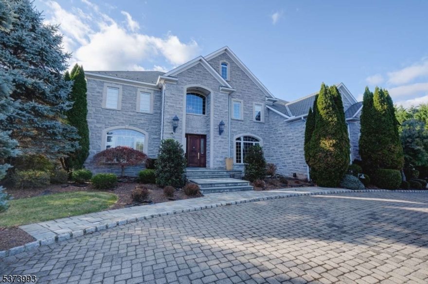 Exquisite custom-built stone estate in prestigious Montville! This beautifully crafted 5BR, 5.5BA home showcases 10' ceilings, elegantly designed custom moldings, hardwood/marble floors, 6-zone HVAC and premium designer finishes throughout. The gourmet kitchen features high-end appliances, sleek cabinetry, and modern butler's pantries. The luxurious primary suite includes a sitting room/office, dressing area, dual walk-in closets, and a spa-like marble bath with steam shower. A spacious walk-up attic offers a versatile rec room, while the expansive fully finished walk-out lower level boasts a second kitchen, living/dining area, flex room with walk-in closet, gym/media room and a second laundry room " ideal for guests or multigenerational living. Nestled on a quiet street in sought-after Montville Township " known for its top-rated schools, charming community and convenient NYC access.