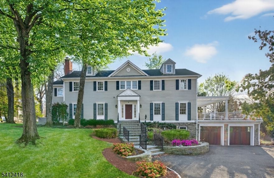 Timeless elegance meets modern sophistication in this stunning custom Colonial built in 2009, ideally located in the desirable Poets Section of Short Hills. Thoughtfully designed across 3 spacious levels, this home blends luxurious finishes with everyday functionality. Enter through the grand foyer with hardwood floors and crown molding to the living and dining rooms showcasing herringbone flooring, custom millwork and built-in audio. The chef's eat-in kitchen features custom cabinetry, quartz countertops, premium stainless steel appliances and a center island, flowing seamlessly into the breakfast area and inviting family room with built-ins, gas fireplace and surround sound. Step outside to a maintenance-free deck with pergola, outdoor speakers, lighting and natural gas grill ideal for indoor-outdoor living. A private office with custom workstations and powder room complete main level. Upstairs, the primary suite offers a vaulted ceiling, dual walk-in closets + a spa-like bath with soaking tub, multi-head shower and luxurious finishes. 3 additional bedrooms including a junior suite + a hall bath and convenient laundry room. The lower level provides a recreation room, exercise space, full bath, mudroom + access to oversized 2-car garage. Smart home features in most of home include audio, security system, generator, multi-zone HVAC and integrated controls. Close to top-rated schools, parks, shopping + NYC transit, this home offers the perfect blend of comfort and convenience.