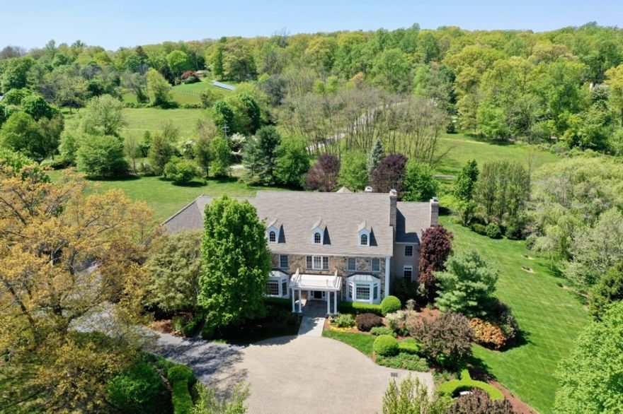 Nestled atop 5 lush acres on Bernardsville Mountain, "Ballantine Manor" seamlessly blends architectural style, comfort, and privacy just minutes from town. The antique gated entrance and tree-lined driveway lead to a stunning two-story foyer. High ceilings, wide hallways, and crown moldings create an inviting atmosphere, connecting living spaces. The great room, flooded with natural light, features a fireplace and a wall of windows framing picturesque views. The gourmet kitchen boasts top-of-the-line appliances as well as an inviting center island for casual dining and a breakfast area and octagonal gathering room with fireplace. The formal dining room and butler's pantry make entertaining a joy. The paneled library with fireplace is ideal for working from home. On the second floor, the primary suite is a tranquil oasis with a spa-like en-suite bath and a sitting room with a fireplace. Four additional generous bedrooms all with en-suite baths and a second floor laundry complete the second floor. The walkout lower level includes a recreation room, bar, home theater, study, and full bath. Outdoor spaces, including patios and a deck, provide a private retreat for relaxation and al fresco dining while the sprawling yard with specimen trees and plantings offers endless possibilities. Minutes from Bernardsville's town center, NYC trains, and excellent public and private schools, Ballantine Manor offers a lifestyle that has it all!