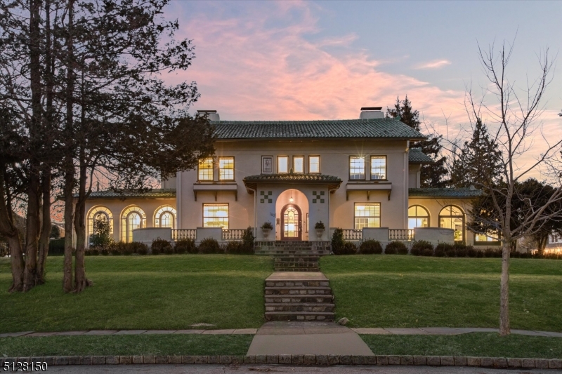 On one of Montclair's most beloved streets, this Italian Revival gem blends Mediterranean elegance w/modern updates. The extensive outdoor renovation w/curated landscaping, Belgian block hardscape, patios & heated in-ground saltwater pool feels resort-like. Inside, amazing flow from the generous open foyer to all rooms makes a perfect home for entertaining. Exquisite moldings adorn the formal dining rm w/a stunning imported tile fpl flanked by built-ins. Another grand fpl w/original tile inlay is the centerpiece for the sunken family rm that leads to the cook's kitchen w/ high-end SS appliances, imported floor tile, Carrara marble countertops & breakfast rm w/raised fpl & built-ins. Sunlight streams into the 2 sunrooms (one w/a working fountain), each w/floor-to-ceiling windows & doors that lead to terraces & the pool. The 2nd floor landing's curved balcony overlooks the grand foyer below & leads to an open office w/access to the outdoor terrace. Cozy up w/a book in the primary bdrm beside the fpl or soak in the gracious en-suite bathtub flanked by leaded glass windows. 3 add'l generous bedrooms & 2 add'l baths complete the 2nd fl. The massive finished basement/rec room feels like an urban loft w/10ft ceilings & storage galore. Huge unfinished 3rd fl attic accessed by a proper staircase provides tons of oppty. Newly reno'd 2-car garage & Belgian block driveway & new sprinkler system. Steps from Watchung Plaza, NYC train, bus, shops, eateries, Edgemont Park, schools & more!