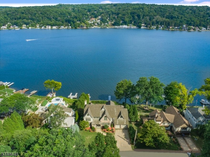 Impressive Tudor style colonial on one of the best lots on desirable Manitou Island. Almost 7500 SF of custom design elegance with panoramic views and ever changing scenery.  Wildlife visits include Bald Eagles & Swans that cruise by.  A sweeping staircase greets you in the foyer with 10' ceilings & crown molding throughout. There is a  beautiful stone FPL in the living room and the open floor plan draws you to the amazing lake views as you enter with morning sun that floods the breakfast room & kitchen with a deck to step outside & take in the day. There are 4 bedrooms on the second floor with a back stairway and spacious primary suite. The lower level walk out has an enormous Rec room, second kitchen, 2 full baths, an office/bedroom and 3 sets of French doors leading out to the wonderful POOL patio area! The home has a 4 BR septic. 5 minutes from the historic White Deer Plaza with restaurants, shops & boardwalk. About an hour from NYC.