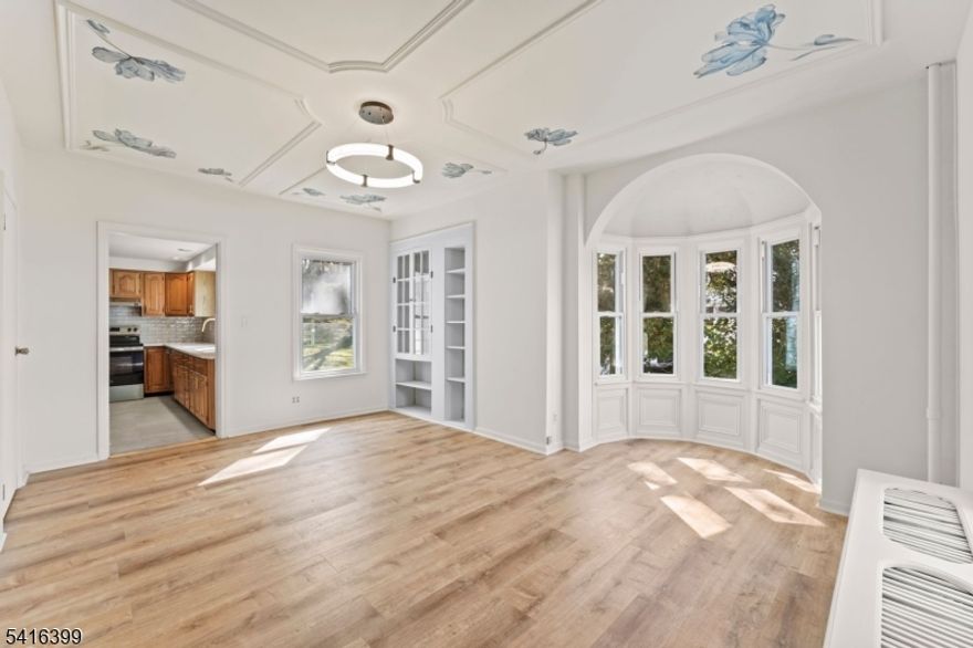 Recently refreshed after a winter event prompted plumbing and well improvements, the home now offers added confidence and peace of mind alongside its historic appeal. Step into timeless country elegance with this beautifully maintained circa 1900 residence, where classic charm meets refined design. The custom mosaic foyer introduces artistry and connection to nature, setting a warm tone. Every element has been thoughtfully curated, from imported wall murals to a bow window accented with golden flakes designed to capture sunlight and create a glow throughout the space. On the first level, find a gracious living room featuring a refurbished fireplace frame wrapped in a handcrafted mural, a nod to the home's original hearth. A formal dining room with original built-in shelving and glass doors offers charm and function, while a plush carpeted center staircase separates the two spaces. The main level also features a full bathroom, laundry area, and an updated kitchen with original cabinetry, brushed gold hardware, and stainless steel appliances. Upstairs are three bedrooms with distinctive moldings and a second full bath showcasing floor-to-ceiling porcelain and glazed ceramic tile. Outdoors, a charming playhouse with its own mailbox adds to the property's countryside character. Property includes Block 30 Lot 5 across the street where a detached two-car garage and additional parking are located, with convenient access to Route 46.