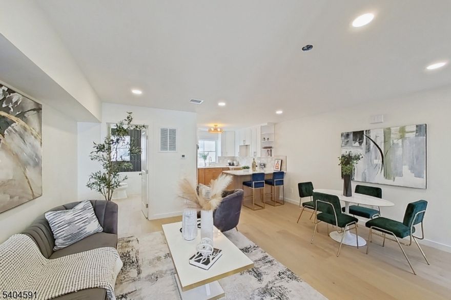 Javier Hill presents a rare opportunity to own a newly constructed townhome community in Passaic, NJ. This exclusive collection of eight thoughtfully designed two-story residences offers the space, privacy, and functionality of single-family living with the ease of modern new construction. Each home features a private, LED-lit entrance and direct interior access from a two-car garage with dedicated mechanical, storage, and laundry spaces. The main living level showcases a bright, open-concept layout ideal for entertaining and everyday living, highlighted by abundant natural light and a decorative pine wood partition that adds warmth while framing the staircase. The kitchen is both stylish and functional, featuring ceiling-height wood cabinetry with crown moulding, white granite countertops, open shelving above the island, full-size stainless steel appliances with range hood and pantry storage. A well-appointed half bath with timeless finishes completes this level. Upstairs, three generously sized bedrooms offer ample closet space, including a primary bedroom with a full walk-in closet. The full bathroom features modern fixtures, a deep soaking tub, glass shower doors, and a custom granite-topped vanity. Additional highlights include central heating and air conditioning, energy-efficient windows and doors and high-set windows for added privacy and natural light. Javier Hill delivers modern design, thoughtful details, and comfortable living crafted for today's lifestyle.