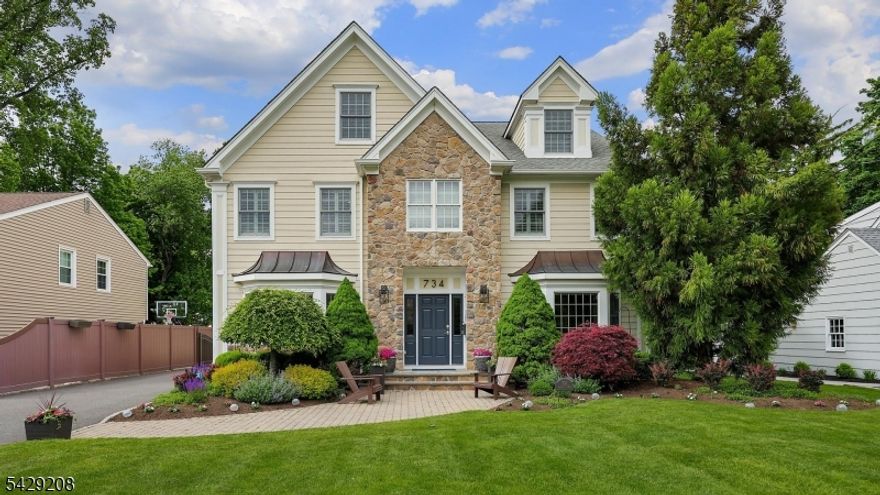 Welcome to this expansive 5 bedroom, 5   bath Colonial that blends timeless charm with modern luxury. A beautifully crafted home with an open floor plan, hardwood floors, natural light, and custom woodwork & details throughout. Step into the 2-story foyer, flanked by a formal living room & spacious home office leading to an elegant dining room. The newly renovated eat-in kitchen is a chef's dream, with an oversized island that serves as the true focal point of the space, a dining area and bar open to the family room, with a vaulted ceiling, wood-burning fireplace, & access to the deck and landscaped backyard. The 1st floor includes a private BR and full bath, as well as a mudroom and powder room off the 2-car attached garage. Upstairs, the primary suite offers a gas fireplace, his-and-hers custom walk-in closets, & a spa-like bath with dual sinks, tub, and shower. Also on the 2nd floor are an en-suite BR w/ bath, 2 additional BRs that share a full bath, and laundry. The 3rd floor hosts an unfinished attic with ample storage. The finished lower level offers even more living space with an oversized rec room, gym, bonus room, storage, & full bath. Outside, enjoy the professionally landscaped, fenced backyard with paver patio, built-in BBQ, & fire pit, ideal for gatherings. Conveniently located near Wilson Elementary School, NYC transportation, and downtown, this home offers both comfort and connectivity. A whole-house generator is an added bonus. This home checks all the boxes!