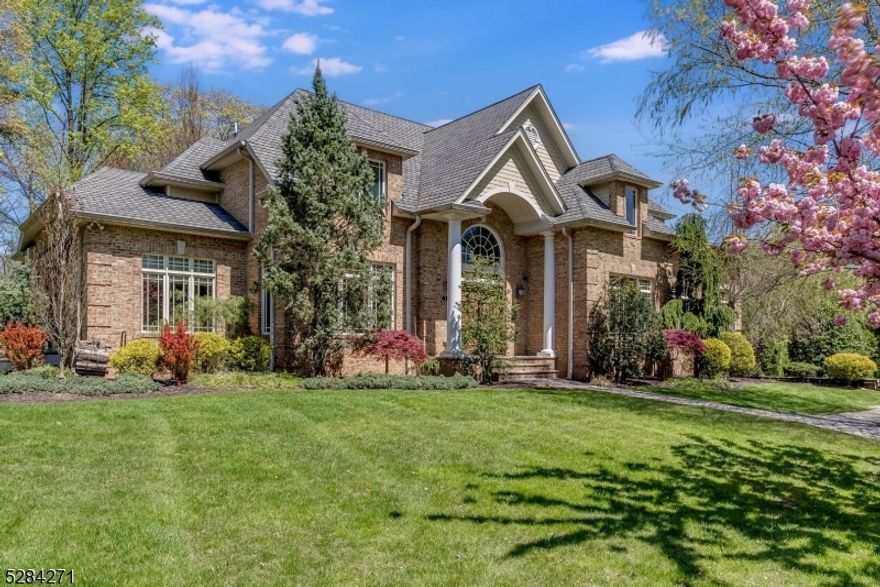 Surrounded by majestic trees and open space sits this stunning brick center hall colonial. Perfectly situated at the end of a quiet street, this home embodies a modern luxury while maintaining the traditional style of colonial architecture. The soaring 2 story entry foyer features crown moldings and beautiful bordered hardwood floors that are throughout the home. Every room has a view, allowing you to enjoy the quiet serenity of your surroundings. The first floor includes a parlor, Living rm, dining rm, butlers pantry, powder room, Laundry rm, bedroom with ensuite and a private office.. The gourmet kitchen is equipped with top-of-the-line appliances, custom cabinetry, and a center island with seating. The Family room features a 2 story stone wood burning fireplace and sliding doors to an amazing back patio with a luxurious hot tub, heated pergola, perfect for al fresco dining and entertaining. The 2nd floor includes grand primary suite which exudes elegance including a gas fireplace, sitting rm, large closets and a spa like primary bath.There are also 2 more bedrooms and hall bath. The lower level has a 3 car attached garage which leads to spacious mud room, gym, wine room, flex tv/media room with full bathroom and large storage room. Perfect for multi generational living. Alarm system, sprinkler system, sound system.This custom home was built with high quality finishes with great attention to detail. Close to Parks, restaurants, shops, schools and houses of worship.