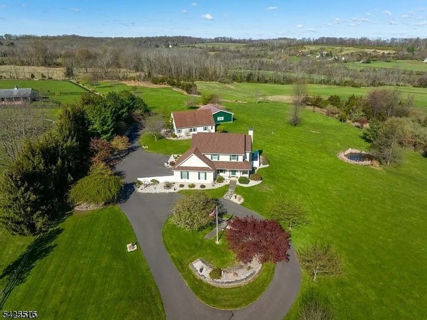 A Sunset Sanctuary in the Heart of Sourland Wine Country. Situated on 5.6 spectacular acres adjacent to a premier local winery, this impeccable custom colonial offers a lifestyle of rare beauty and tranquility. Imagine ending every day with breathtaking sunsets over the rolling farmland and vineyards of scenic Amwell Valley?views that are yours to enjoy from nearly every room. This modern-day farmhouse, built in 1995 and meticulously maintained, features an open-concept plan elevated by stylish new flooring, a high-efficiency geothermal HVAC (2013), and a new roof (2015). Solar panels over the smaller garage are contributing to complete this eco-efficient home. The main level flows effortlessly from the sunny two-story foyer to the heart of the home: an open Kitchen, the sophisticated Formal Dining and Family Room suite. Located just off the entry, the dining room can also be used as a quiet home office or a sophisticated formal dining room. Car enthusiasts and hobbyists will find their paradise here with 7+ garage bays , including two detached, oversized garages with expansive parking for every "toy." The impressive grounds, featuring a pond, circular driveway and ample room for equestrian or agricultural pursuits, are located within an award-winning Blue Ribbon school district. Enjoy the ultimate blend of rural serenity and convenience, just minutes from Flemington, Princeton, and the vibrant Lambertville/New Hope river towns.