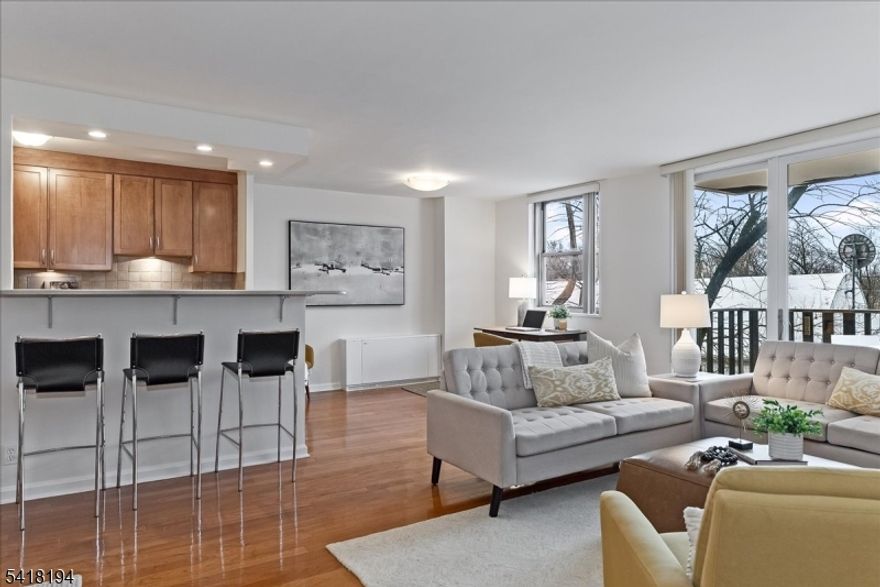 It's your favorite building and you've been waiting for a unit like this one! Gorgeously updated, this sunny 3d floor unit has the floorplan you want and the finishes you're hoping for. Hardwood floors throughout, great light fixtures and fresh paint feel warm and inviting. The Kitchen is tastefully updated, with gleaming wood cabinets, granite counters, stainless steel appliances and an open view over the breakfast bar to the Dining Room, balcony and beyond. The open layout allows for multiple seating/work areas, plus a formal Dining area. New sliding glass door fills the space with light and allows easy access to the large, priviate porch - perfect for your morning coffee or al fresco dinner. The Primary Bedroom is spacious with bright, updated en suite Full Bath and double closet. A second large Bedroom is perfect for whatever you want - guests, office, TV room - with a second, updated Full Bath just across the hall. Unbelievable closet space including two walk-ins. Laundry at each end of the floor is the ultimate convenience. Three-zone heating/cooling will keep you perfectly comfortable, year round, and the HOA includes all utilities! Right in the heart of bustling Upper Montclair Village, steps to NYC train & bus, the sought after Bellaire House is the only building in Montclair with 24 hour attended lobby, elevators, indoor & outdoor parking, private pool, landscaped outdoor seating and dog run, plus laundry on every level. And pets permitted (with limits)! Perfect.