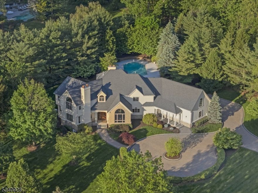 Luxury living at its finest! Set on an expansive 1.9-acre lot on one of Warren Twp's most desirable streets, this Ferruggia built & Beer Coleman designed home is crafted w/ architectural distinction and quality finishes thru-out including arched doorways, detailed moldings, custom picture windows, & beautiful mahogany front door & impressive two-story foyer w/ sweeping staircase. The thoughtfully designed layout includes a first-floor guest suite, spectacular LR - Library w/ gas FPL to read & relax, stunning two-story dining room for entertaining, spacious family room w/ wood-burning FPL & 2 French doors. The gourmet kitchen w/center island & large breakfast area has access to the covered porch and patio that overlook a resort-style in-ground heated pool w/ cool deck & professionally landscaped fenced backyard + dog run. 2nd level adorns the primary suite, a serene retreat featuring a gas FPL, HW floors, oversized walk-in closet w/ built-ins & luxurious bath. Three add'l BRs include an ensuite BR w/ bath + 2 BRs which share a Jack-and-Jill bath setup. Sun-drenched 2nd fl bonus room offers flexible space for a 2nd FR. playroom, office or gym. Extra height basement offers endless possibilities, currently used as a gym & rec space. Other notable features: Circular paver driveway ('22), 3-car garage, newly repainted hard coat stucco exterior ('25), new roof ('24), built-in house generator ('17), new pool heater ('24) & new pool cleaner line ('23)