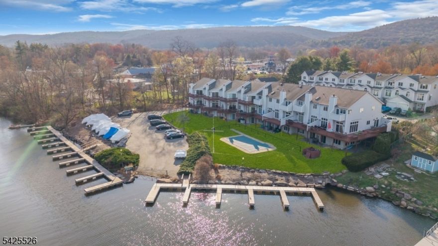 Experience lakefront living at its finest in this exceptional end unit townhome on beautiful Greenwood Lake NJ. Perfectly positioned within the community offering a full unobstructed view of the lake, the community in-ground pool, and the private marina, this property has an unmatched vantage point that truly sets it apart. Designed to embrace its surroundings, the home features the largest wrap-around deck in the neighborhood, creating a seamless indoor-outdoor lifestyle. Whether you're enjoying morning coffee at sunrise, hosting gatherings with friends, or unwinding as the sun sets, this expansive outdoor space delivers a front-row seat to it all. As an end unit, the property benefits from added privacy, abundant natural light, and a more open, airy feel throughout. Every detail of the setting enhances the sense of retreat, yet you're still part of a sought-after lakefront community with convenient access to everything Greenwood Lake has to offer. This is more than just a home, it's a rare opportunity to own one of the most desirable and uniquely positioned properties in this community. HOA will be installing a new roof in the 2026 year, at no additional HOA cost to owners. This home includes a new boiler less than a year old, and new A/C from 2024.