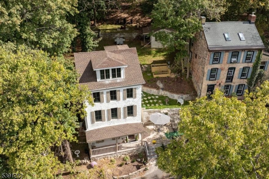 Tucked away on Lambertville's hidden gem, Weeden Street feels like a private European enclave just steps from town. With only a few homes on this quiet lane and few true single-family residences in Lambertville this property is a rare find. The hum of the Delaware River and nearby Towpath trail set a tranquil rhythm, blending small-town charm with a refined sense of escape. Fully reimagined, this four-story home combines timeless craftsmanship with European flair. Designer finishes and quality materials shine throughout from quartz kitchen counters and custom cabinetry to gleaming floors and updated lighting. All systems roof, plumbing, and electrical are new, preserving character while offering modern comfort. The entry level features a flexible space with a full bath and porch, ideal for a home office or guest suite. The second floor opens to a bright living area with a sleek kitchen, stainless appliances, center island, and cozy dining nook. A walk-in pantry with electricity adds charm and function. The third floor offers a serene bedroom suite with a walk-in closet, full bath, and laundry. The top floor is a light-filled retreat perfect for a studio, gym, or guest space with treetop views and river glimpses. Outdoor spaces include terraces, a stone-walled courtyard, and a detached outbuilding with electricity ideal for a studio or future guest casita. Just blocks from dining, galleries, and boutiques, this unique home offers elevated small-town living.