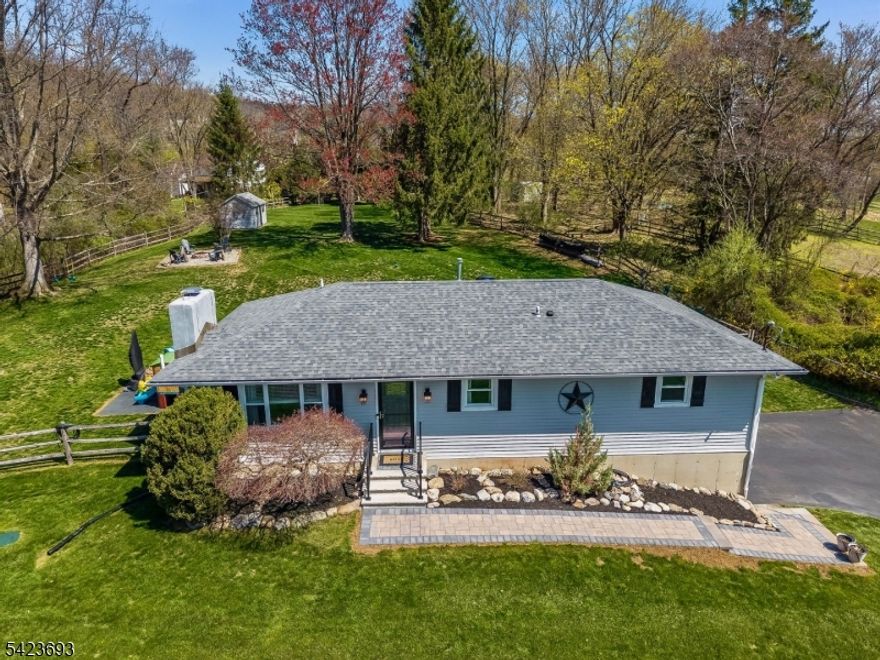 Beautifully maintained ranch offering exceptional comfort, thoughtful upgrades, and inviting indoor and outdoor living spaces.  A professionally designed paver walkway creates a warm & welcoming first impression.  Step inside to find gleaming hardwood floors throughout the main level, complemented by a cozy stone front wood-burning fireplace & ceiling fan in the living area-perfect for relaxing or entertaining.  The updated kit features a stylish new backsplash, center island, recessed lighting, & convenient pull-out cabinet drawers for optimal storage & functionality.  The primary bedroom offers a private retreat with its own full bath, ceiling fan & TV wiring.  The renovated hall bath (2023) showcases modern finishes & includes a charming sliding barn door for easy access to the linen closet.  The fin basement expands your llving space w recessed lighting, a laundry rm w/a half bath & under stair storage w/custom built out roll out pantry.  A WIC w custom organizer adds more versatility.  Additional upgrades include an expanded garage w/new electric panel, smart hot water heater w/WiFi capability & auto shut off (2025), generator hook-up (2025), new well pump (2025).  Stunning fully fenced backyard designed for both tranquility & entertaining.  Enjoy the Trex deck, a 20 x 30 paver pati0, fire pit area, garden cove and newer shed (2024).  This move in ready home offers the perfect blend of charm, modern updates & functional living-don't miss the opportunity to make it yours!