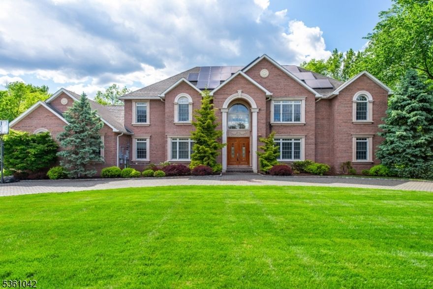 WOW factor!  Discover this stunning 6-bedroom, 5.5-bath, 5.6 acre home, featuring a full brick/ stucco exterior, w/solar power, soundproof construction, circular driveway, and a 3-car garage.Built in 2010, this East-facing residence offers luxurious living with 9-foot ceilings on every floor and hardwood floors throughout, including inlaid wood accents.  The two-story foyer, with chandelier adds a dramatic touch.The home includes two laundry rooms, spacious kitchen with granite countertops, a Viking 6-burner range, Sub-Zero fridge/freezer, heated tile floors, custom cabinetry, pot filler, large center island with eat-in area and formal dining room.. The family room features fireplace, custom moldings, inlaid wood floors, and coffered ceilings.A two-story living room is adorned with custom moldings, fireplace and an elegant chandelier. Additional den with double French doors and coffered ceiling and 1st fl primary suite with sitting area, walkin closets and full en suite bathroom.  Upstairs, the en suite bedroom includes an attached bath, while two additional bedrooms share a Jack-and-Jill bathroom.The bridge offers access to the 2nd fl primary suite offers high ceilings, hardwood floors, a wet bar, walk-in closet, and a luxurious custom bath with a Jacuzzi tub, double sinks, and a stand-up shower. access to a Trex deck overlooking fenced yard.The finished walkout basement has additional bath, a bedroom (currently a gym), a large rec room, and a home theater room.4 zn AC/heat.