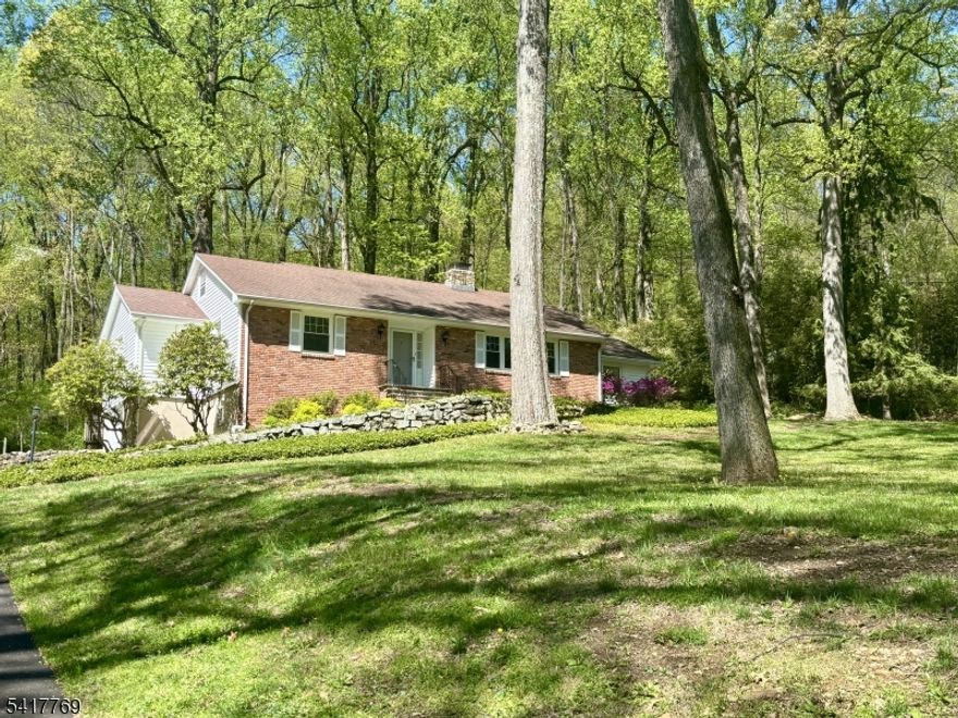 This nicely updated brick-front ranch offers spacious comfort and modern amenities on a private 2.63 acre wooded lot. Inside, you'll find gleaming hardwood floors, generously sized rooms, and an updated kitchen featuring granite countertops, maple cabinetry, undermount sink, SS appliances and larger plant window. The home includes updated bathrooms - one with a walk-in shower in the primary suite and a main bath equipped with an overhead heat vent. The large living room highlights a wood-burning fireplace with a stone hearth, and the formal dining room offers built-in cabinets for added charm and storage. A fourth bedroom doubles perfectly as an office, and a large pantry adds convenience. There is an enormous amount of storage and closet space! The partially finished basement features a family/rec room, powder room, storage cabinets and a workbench. An oversized 2 car tandem garage with an automatic opener along with a spacious driveway offers plenty of parking space. Additional features include a fully floored walk-up attic, and all appliances, including a Generac generator, are included. Enjoy outdoor living with a screened gazebo quipped with a bar and concrete patio, ideal for entertaining or relaxing in peaceful surroundings that back to the woods.
