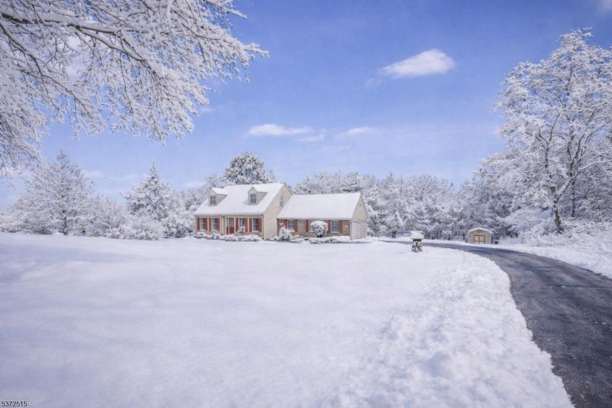 Set on 2.45 acres along a scenic Country Road in Frelinghuysen Township, this inviting brick-front Cape Cod offers space, comfort, and privacy in a peaceful country setting. A charming paver walkway leads to the front door and into a slate-floored foyer. Hardwood floors extend through the formal living and dining rooms, creating warm and functional gathering spaces. The family room with fireplace opens to a spacious deck overlooking the backyard and fire pit, perfect for everyday living and outdoor entertaining. The eat-in kitchen is equipped with granite countertops, stainless steel appliances, and a large walk-in pantry, with convenient access to the two-car garage. Upstairs features three bedrooms and a full bath. The finished walkout basement, complete with an additional full bath, provides flexible space for recreation or guests. With abundant storage throughout and a large detached shed, this well-maintained home delivers the best of country living with room to grow.