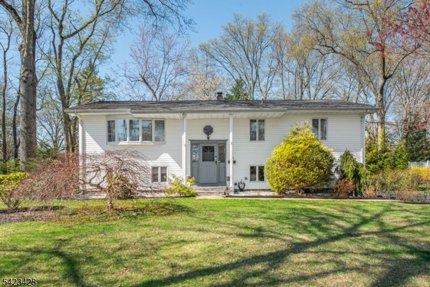 Welcome to 14 Green Drive in desirable Hanover Greens section of East Hanover! This spacious 4-bedroom, 2.1-bath bi-level home sits on a large corner lot in a prime location near Frank J. Smith Elementary School. Step inside to find an inviting open-concept main level featuring high ceilings and abundant natural light throughout the living and dining areas. The updated kitchen is a true highlight, complete with stainless steel appliances, beautiful granite countertops, and seamless flow for everyday living and entertaining. Down the hallway you'll find a full hall bath and three nicely sized bedrooms including a private primary suite with an updated en-suite bath. An additional office space off the Dining area provides flexibility and includes direct access to the backyard. The ground level expands your living space with a comfortable recreation room, an additional bedroom, powder room, and a convenient laundry area. A side loading two-car garage and driveway offer ample parking and storage. Enjoy outdoor living on the large deck overlooking the expansive yard, plus a storage shed for added convenience. With its versatile layout, modern updates, and fantastic location, this home offers the perfect blend of comfort and functionality. Don't miss this opportunity to make it your own!
