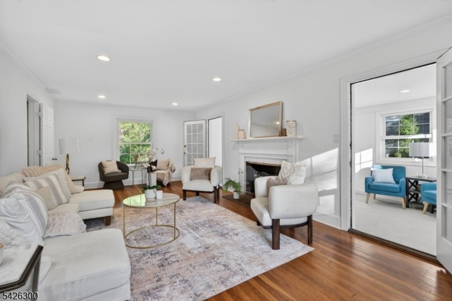 Exceptional Center Hall Colonial nestled in the highly sought-after Knollwood section of Short Hills, just blocks from vibrant downtown Millburn, Midtown Direct trains to New York City, and top-rated Millburn schools. Filled with natural light, the living room features newer windows, a classic wood-burning fireplace and elegant French doors opening to a den or home office. The den offers newly installed carpeting, recessed lighting and walls of windows overlooking the beautiful front and back yards. The formal dining room is rich in timeless charm with chair rail molding and abundant sunlight. The beautifully updated eat-in kitchen showcases white cabinetry, quartz countertops, stainless steel appliances, breakfast island, separate dining area + direct access to the sunroom, private backyard with breezeway 2-car garage. Upstairs, the spacious primary suite features hardwood floors, walk-in cedar closet and a newly renovated bath with sleek finishes and floating vanity. Additional bedrooms are bright and generously sized with hardwood floors and ample closet space, while the updated hall bath is finished in travertine marble. The 3rd floor adds two flexible rooms perfect for bedrooms, offices, or guest space. The freshly painted lower level provides new carpeting, exceptional storage, utility space + walkout access. With extensive updates + unbeatable location near shopping, dining, transportation and Newark Airport, 85 Whitney Rd offers the best of refined suburban living