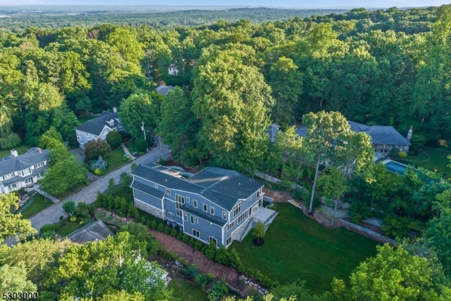 Award winning architect Tom Baio & renowned interior designer Karen Wolf have created a masterpiece on a quiet cul-de-sac. Step into unparalleled luxury within this 9,000 square foot estate, perfect for creating timeless memories. The home's design encourages a lifestyle of elegance and comfort, showcased by the herringbone floors which lead to the expansive living spaces. Custom millwork by artisans can be found throughout the home. Sunlight streams in through the floor to ceiling window wall. The gourmet kitchen, complemented by a hidden pantry, with sleek top-of-the-line appliances is perfect for any chef. A stunning new concept of a double sided refrigerated wine wall in the butler's pantry adds a touch of elegance. The fully-glassed open-concept office exudes sophistication, with iron accents throughout. Whether you are inside the great room or out relaxing on the stone patio, the double-sided fireplace adds warmth and ambiance to the space. The luxurious owner's suite offers a personal sanctuary with his and her walk in closets and  spa like bath while additional bedrooms on every floor, all en-suite, ensure comfort for all. With a walkout  lower level, one can find a full bar, luxury gym, and media room, offering endless entertainment options. Meticulously landscaped grounds and outdoor spaces elevate everyday living. The expansive three-car garage provides ample space for your vehicles and storage needs, ensuring that everything has its place. Live the dream.