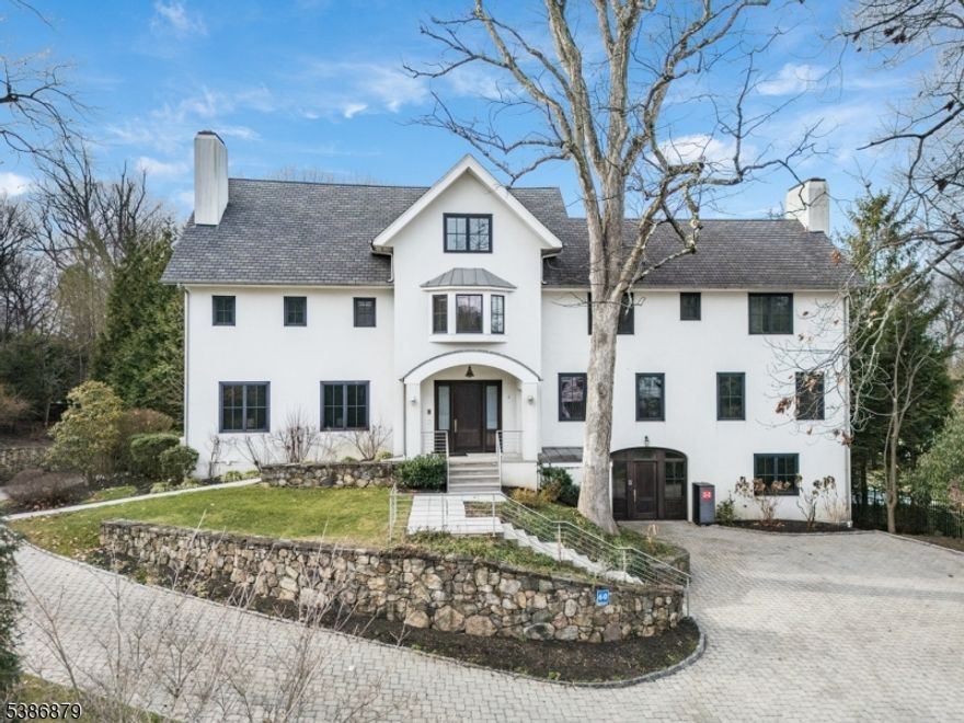 BOLD MODERN LUXURY ON SUMMIT'S COVETED NORTHSIDE ? 1.8 Private Acres. Early 20th-c. home completely reimagined in 2011 into 9 Bed/7.2 Bath showpiece sure to impress all who cross her threshold. Grand circular driveway leads to home sitting entirely above ground on 1.8+ acres of lush greenery w/ stone walls, privacy hedges, ample parking areas, attached 3-car garage & fenced-in backyard w/ multi-tiered concrete tile patios. Museum-like Grand Foyer sets stage for artisan ambiance that features soaring ceilings, floor-to-ceiling mirrors, beautiful lighting, exposed ductwork and sleek steel & frosted glass doors. Living Room w/ concrete fireplace & built-in shelves. Dining Room's massive sideboard & two china closets are an entertainer's dream. Family Room open to expansive Eat-in Kitchen w/ 2 islands, sinks, high-end appliances (Sub-Zero fridges, Wolf wall ovens, Miele dishwashers) & fabulous storage space in sleek lacquer white frameless cabinetry. Sitting Room, Sunroom w/ fireplace & Outdoor Kitchen w/ Wolf grill & fridge complete living space on this level. Primary Suite worthy of 5-star resort w/ sprawling boutique-like dressing room/closet/bath & shower room. 4 Beds on 2nd Level, 3 on 3rd and 2 on Lower Level create ample room to retreat. Lower Level continues resort feel w/ 75' indoor lap pool, hot tub, exercise room & wine room. Discerning buyers w/ an eye for minimalist design will cherish the chance to call 60 Fernwood home! Tax Appeal in progress, call for details.