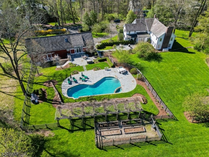 This exceptional residence departs from the ordinary with its modern amenities and farmhouse charm, blending the old and new perfectly and transforming this 5 bedroom, 5 full bath home into the perfect country retreat ideal for living and entertaining inside and out. Art Palombo, award winning architect designed/renovated the main house and barn into functioning and aesthetically pleasing living spaces. The main residence boasts an expanded gourmet white kitchen, a chef's paradise with lots of light, tons of cabinetry, and walk in pantry, a dramatic family room with cathedral beamed ceilings and stone fireplace, versatile office spaces, a primary bedroom oasis with cathedral beamed ceilings, fireplace, spa like bath, and large walk in closet. The refurbished party barn adds the crowning touch to this country retreat with salvaged beams left exposed, the barn living space has a summer house feel and acts as the pool house with large open living, dining and kitchenette space, mudroom with cubbies, full bath, changing room, laundry and loft. The blue stone patio around the pool area includes an outdoor kitchen and the second patio extends from the main house with stone pizza oven and stone steps tying the two areas together. The lower level of the barn is reserved for a 3 car garage and the next level an expansive storage loft with a cedar closet. This exceptional landscaped property enjoys mature plantings, sweeping lawns, a meadow, vegetable garden and meandering stone walls.